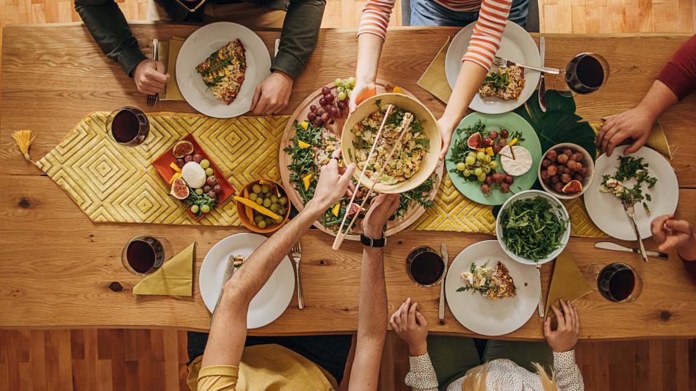 Freunde sitzen gemeinsam am Tisch und geniessen ein leckeres Essen.