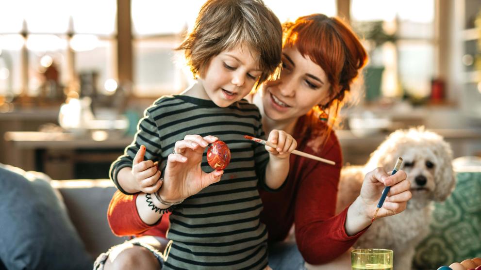 Eine Mutter und ihr Sohn bemalen kreativ Ostereier zu Hause