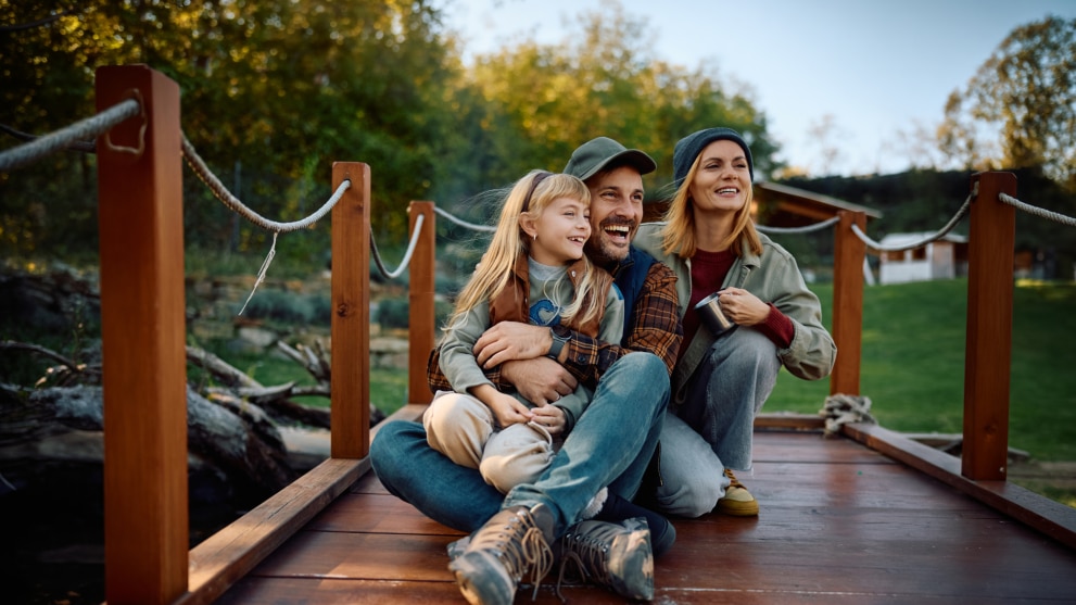 Fröhliche Familie sitzt auf einem Steg
