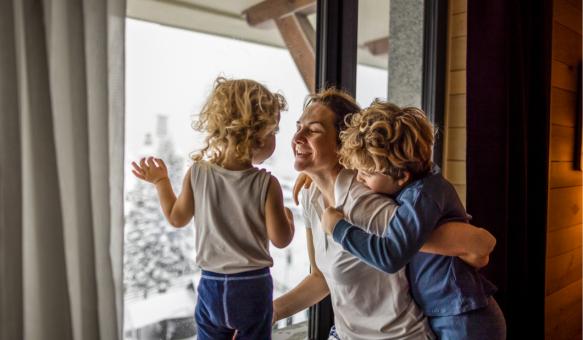 Glückliche Familie schaut im Winter aus dem Fenster