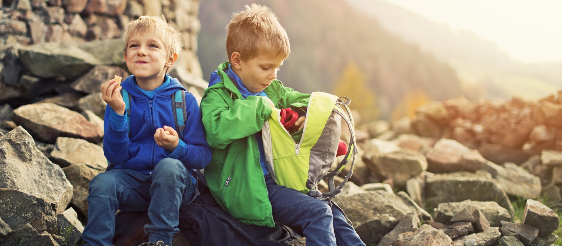 Kinder, die einen Snack essen in der Natur bei einer Wanderpause