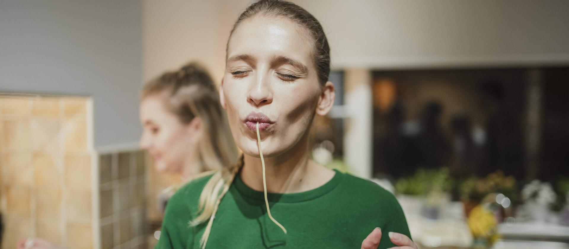 Eine Frau schlürft Spaghetti mit Genuss