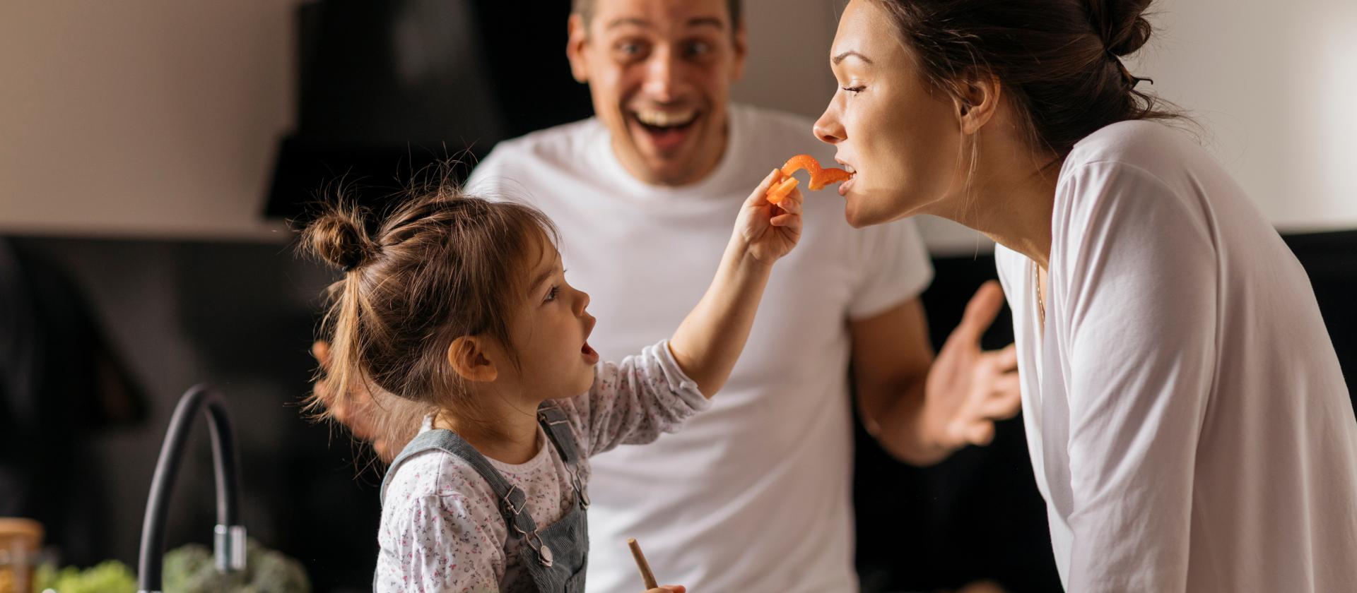 Kind füttert ihre Mama mit einer Paprika