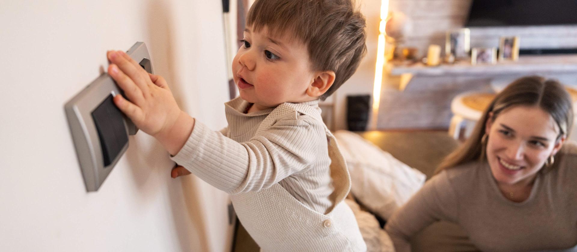 Jeune enfant qui appuie sur l'interrupteur