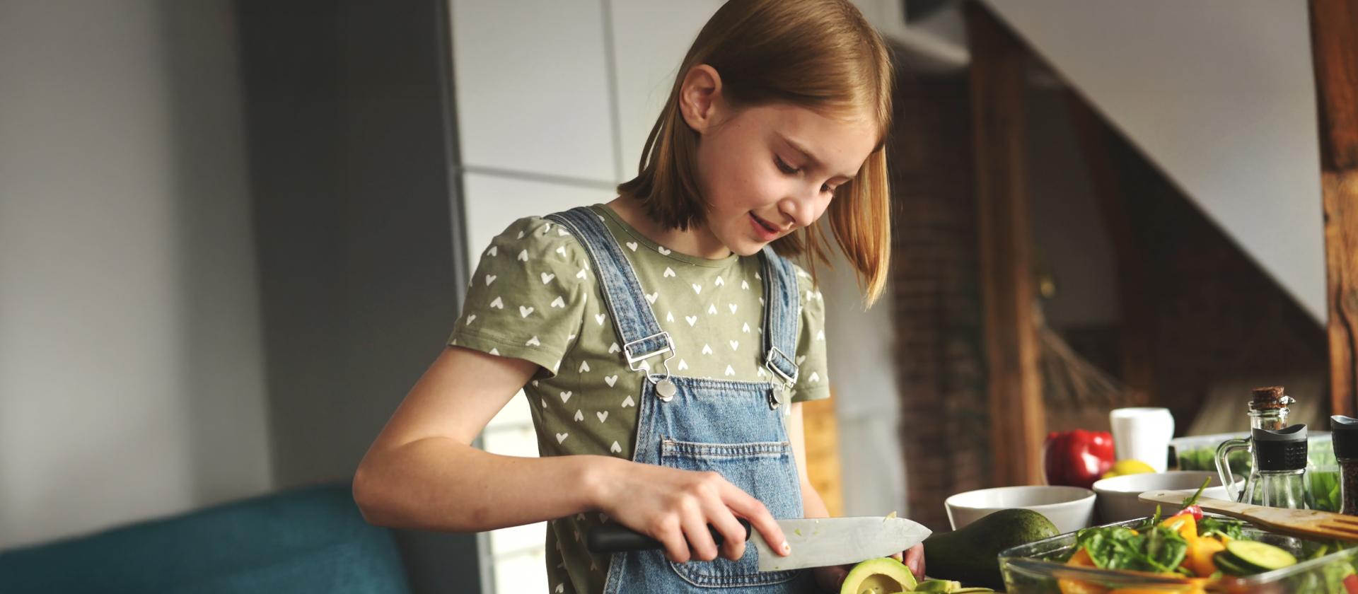 Kind schneidet in der Küche Gemüse