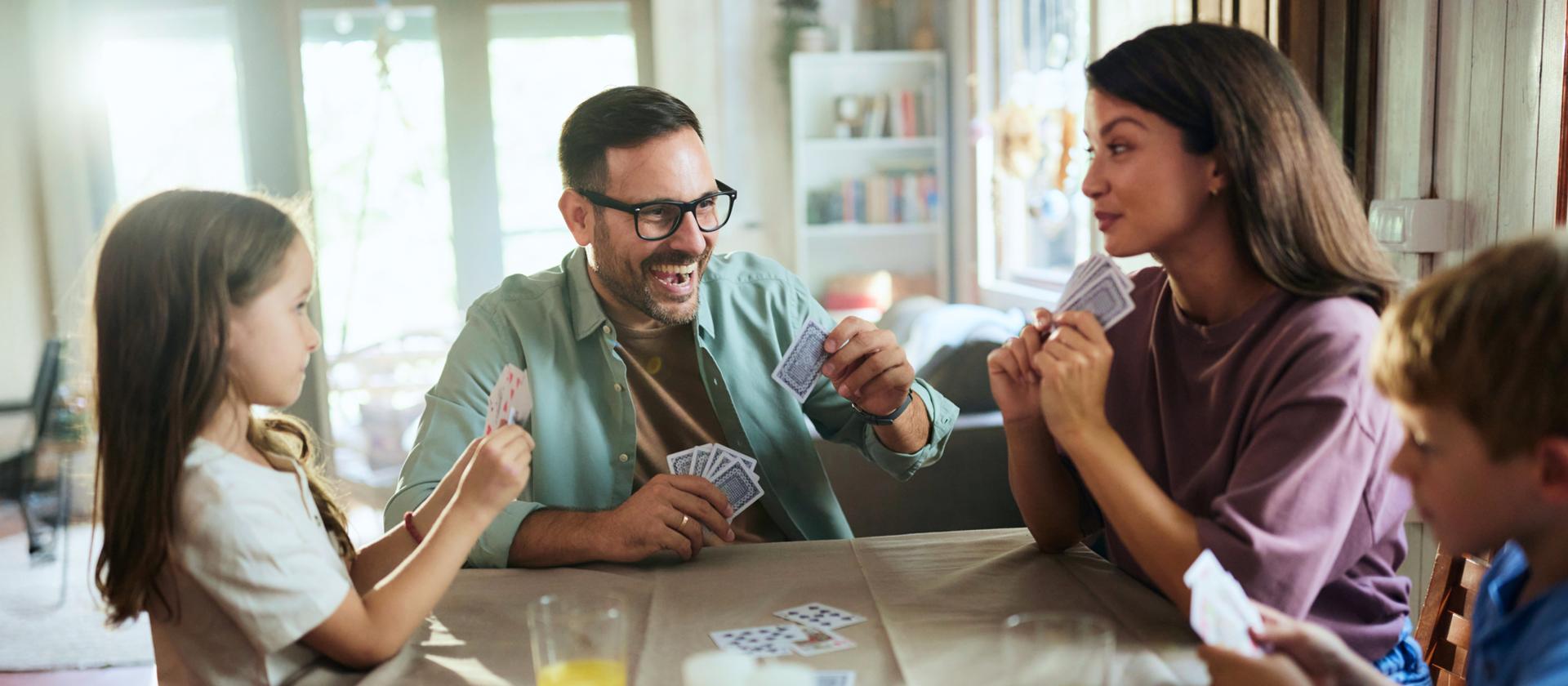 Familie spielt zusammen Karten