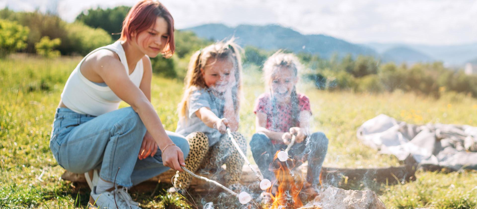 Geschwister grillen an einem Lagerfeuer 