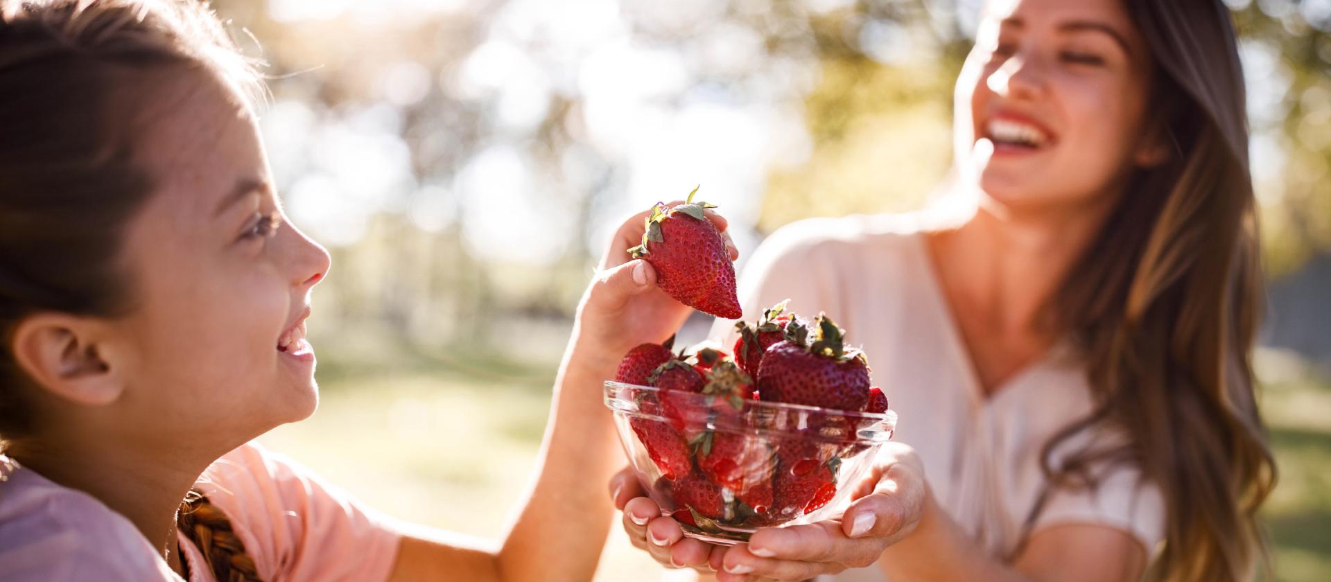 Mutter und Tochter essen Erdbeeren 