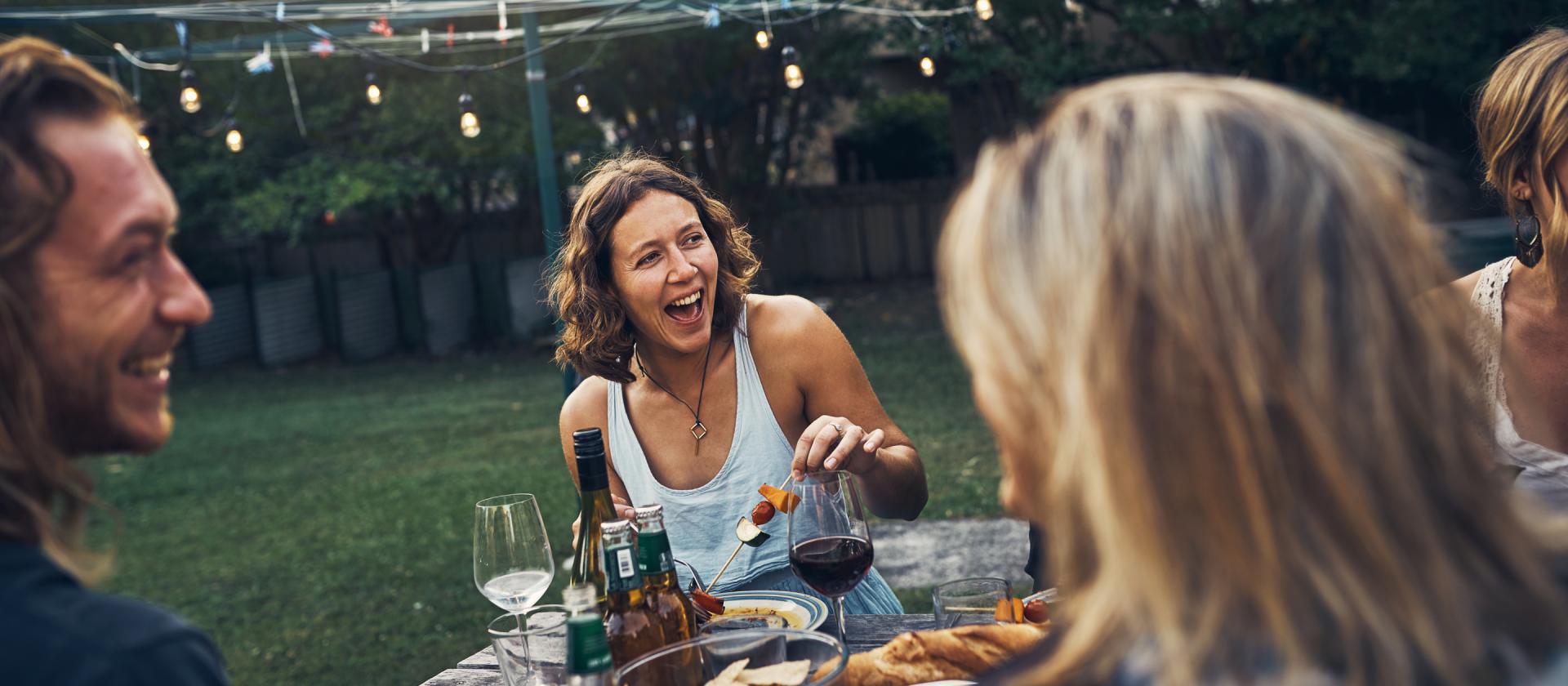 Freunde geniessen ein Essen im Freien im Garten 