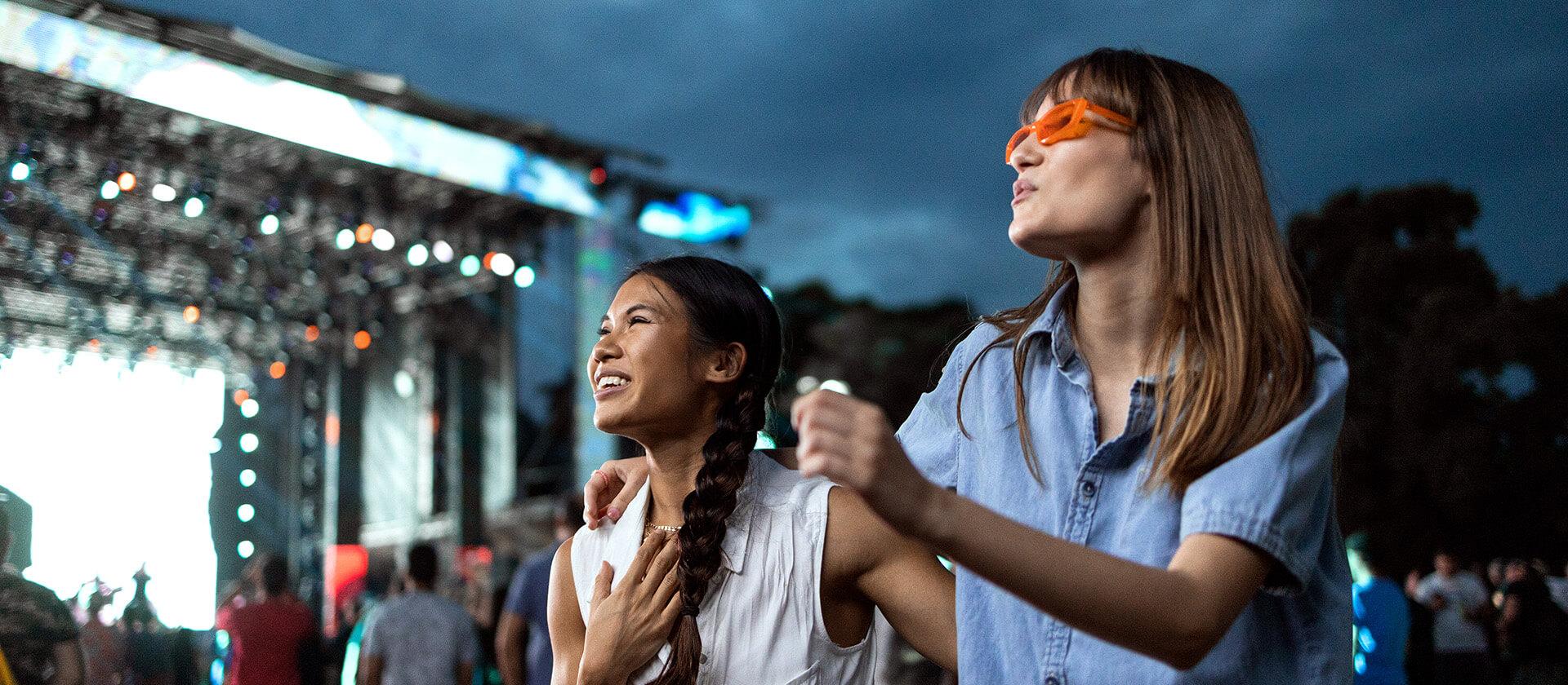 Zwei Mädchen tanzen auf einem Musikfestival.