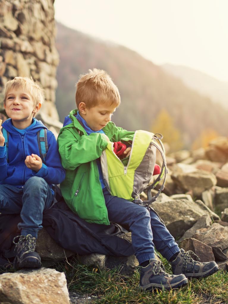 Kinder, die einen Snack essen in der Natur bei einer Wanderpause