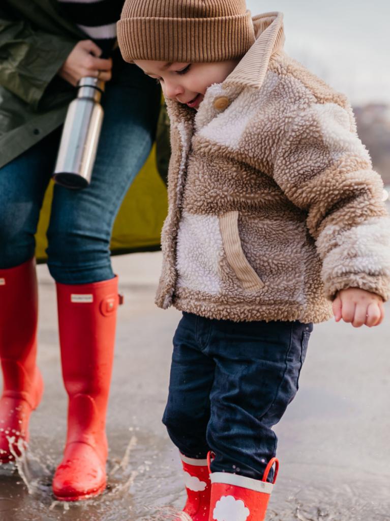 Kind spielt in der Pfütze 