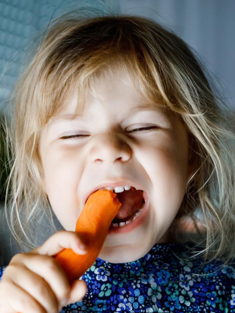 Kind isst eine Karotte