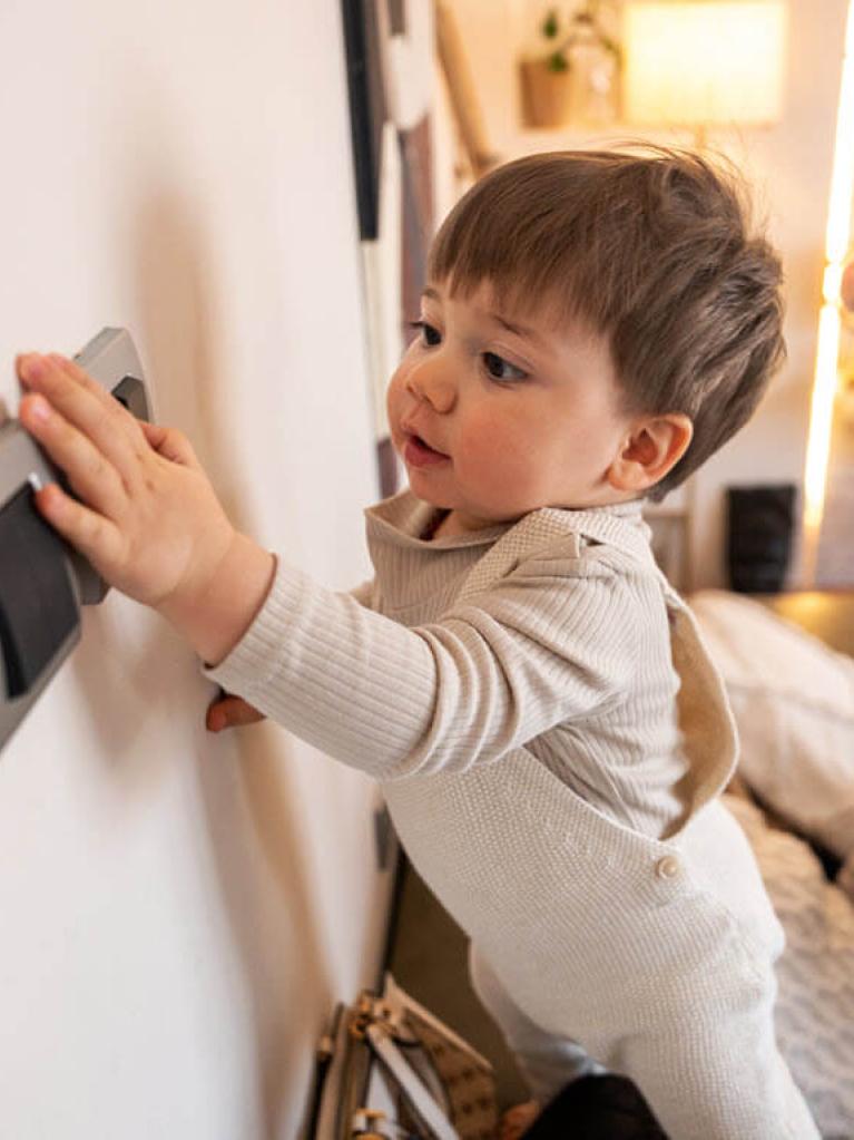 Kleines Kind, das den Lichtschalter betätigt