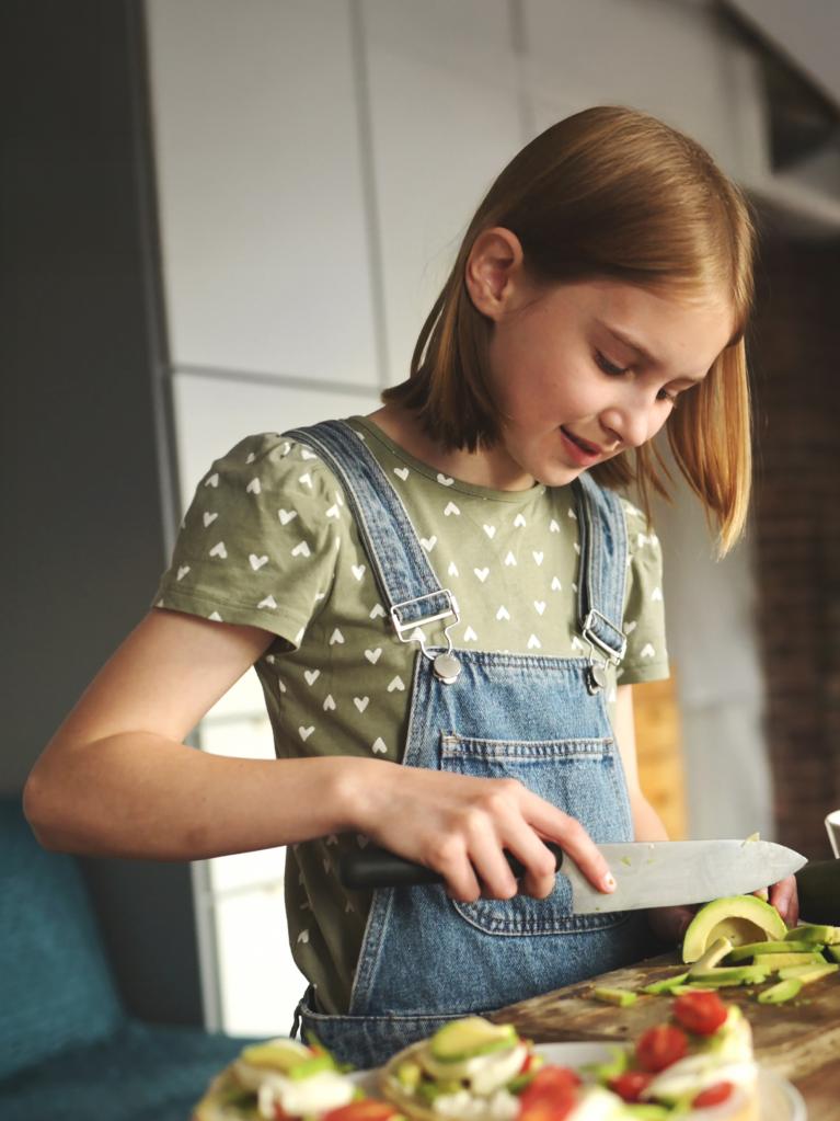 Kind schneidet in der Küche Gemüse