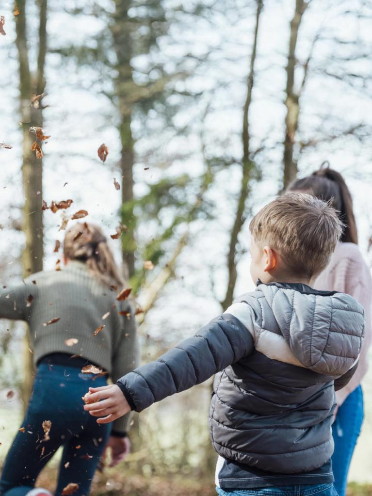 Un garçon et sa mère jouent dans la forêt