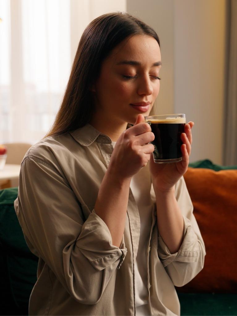 Frau geniesst einen Kaffee auf der Couch 