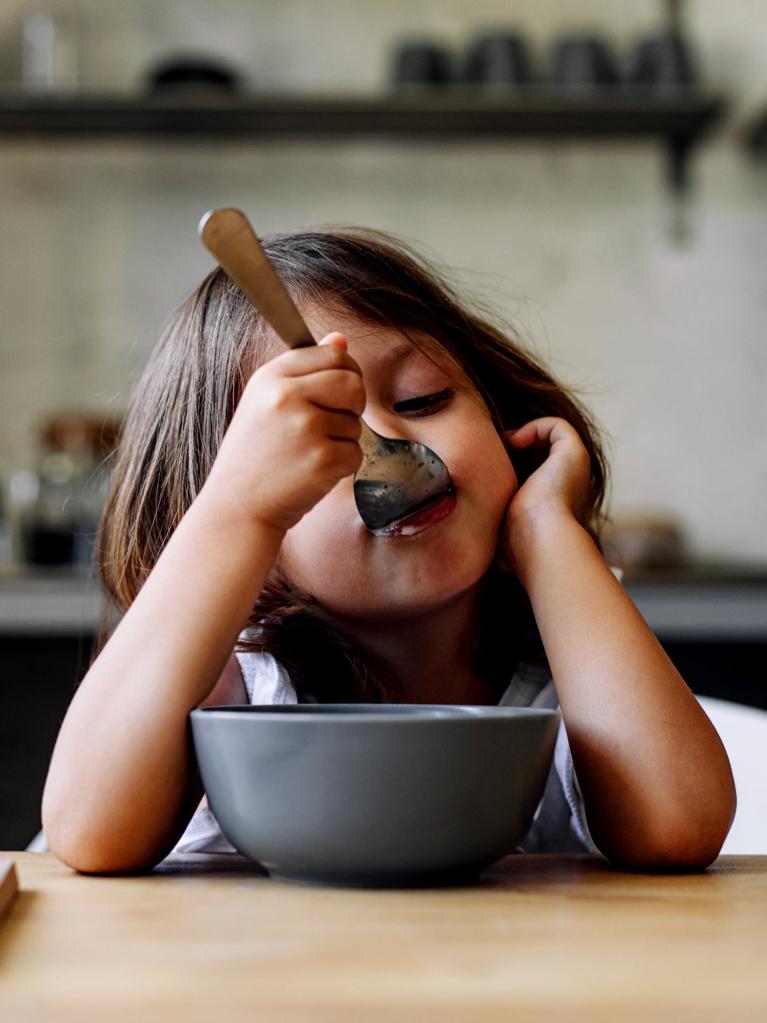 Kleines Mädchen isst Müsli