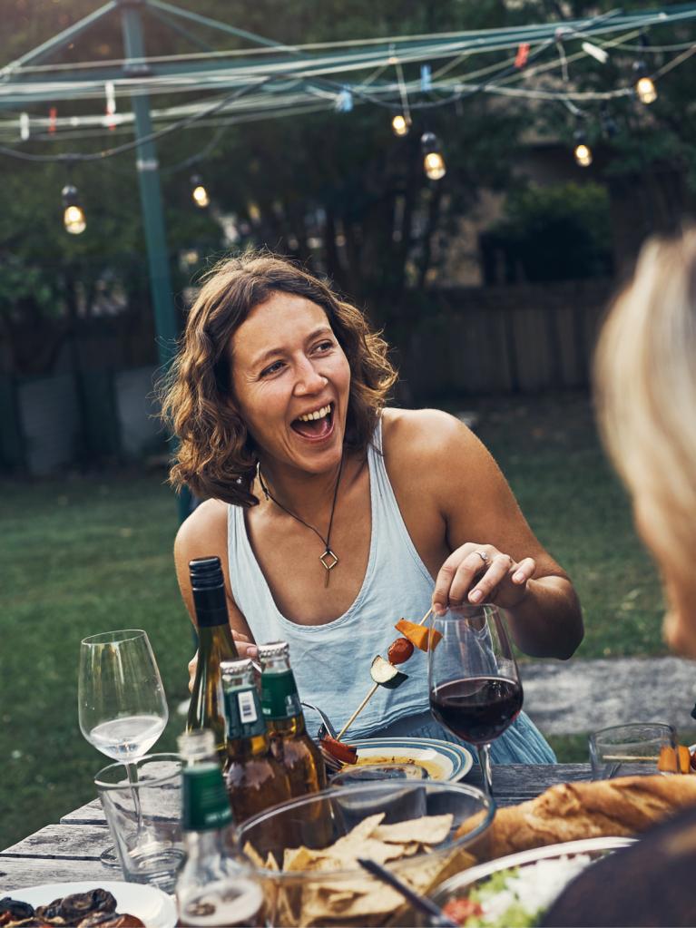Freunde geniessen ein Essen im Freien im Garten 