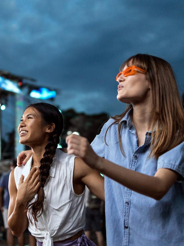 Zwei Mädchen tanzen auf einem Musikfestival.