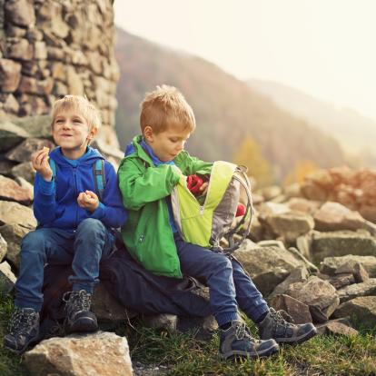 Kinder, die einen Snack essen in der Natur bei einer Wanderpause