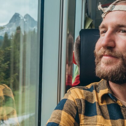 nachhaltiger Urlaub.png Mann fährt im Zug