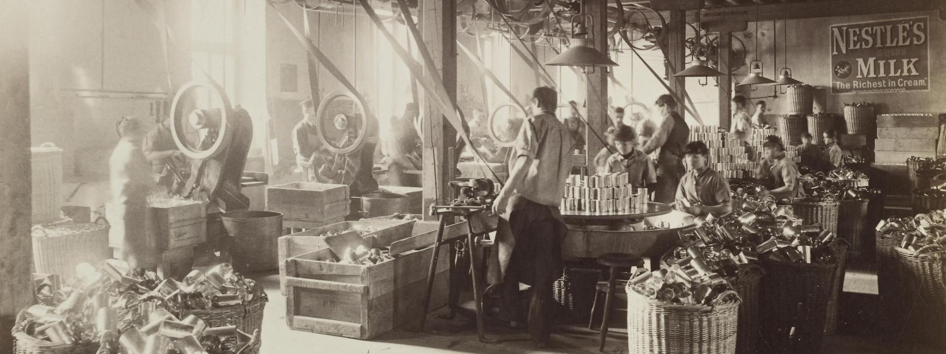 Ein altes Foto von Arbeitern in der Nestlé-Kondensmilchfabrik zu Beginn des 20. Jahrhunderts