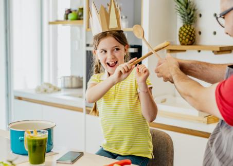 Mann und Kind albern in der Küche herum