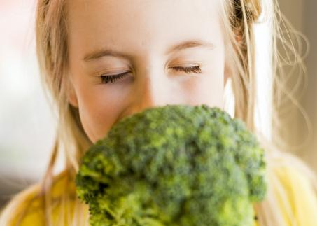 Kind riecht an Brokkoli