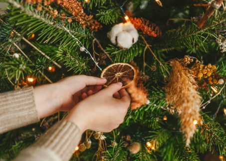 une femme décore un arbre de Noël