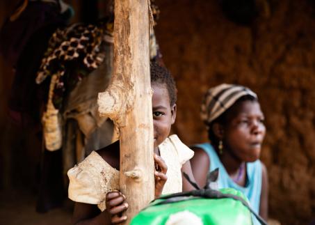 Ein Kind versteckt sich hinter einer Mauer und schaut teilweise hervor