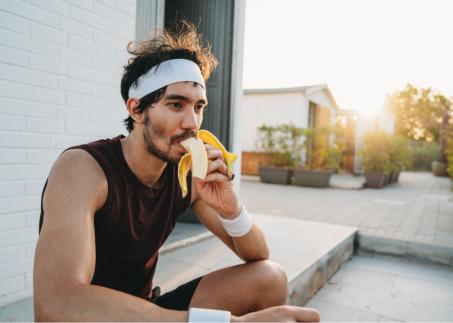 Ein Sportler isst eine Banane