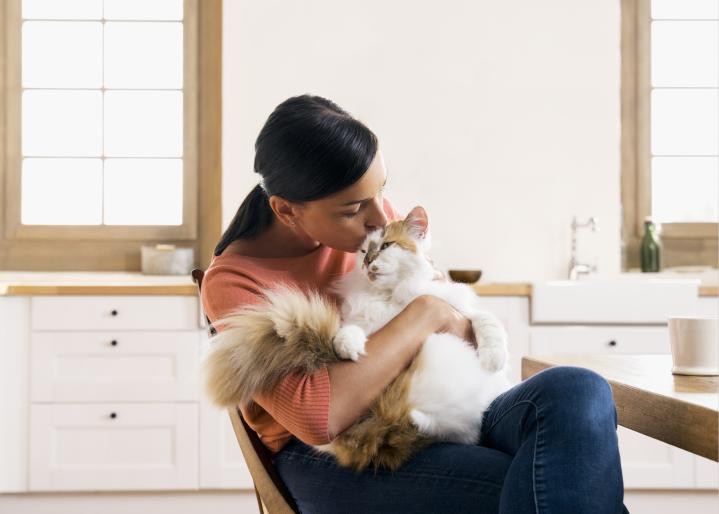 woman in her kitchen with cat on her lab card