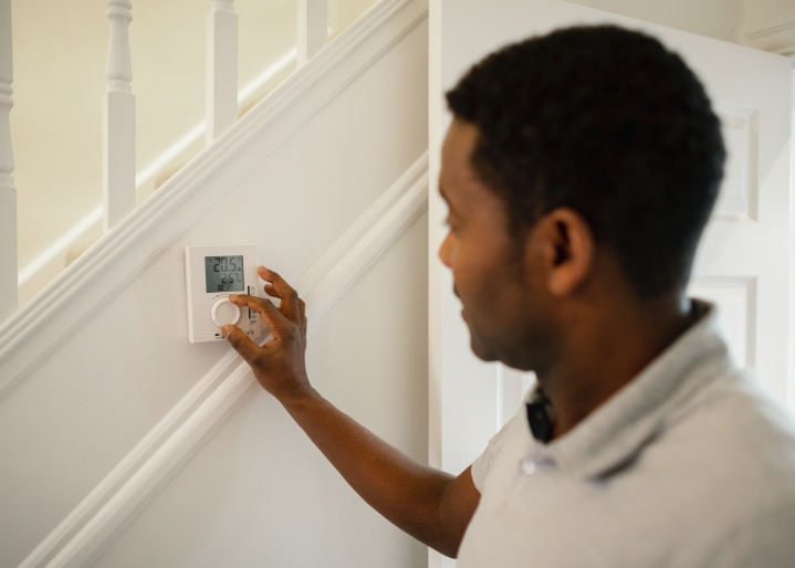 Mann dreht Heizung runter