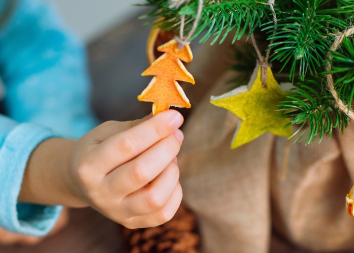 Kind schmückt den Weihnachtsbaum