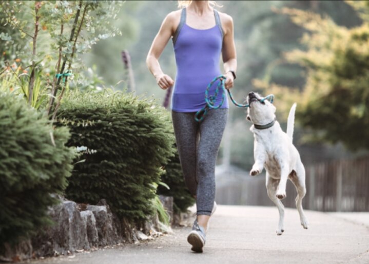 une femme fait du jogging avec son chien