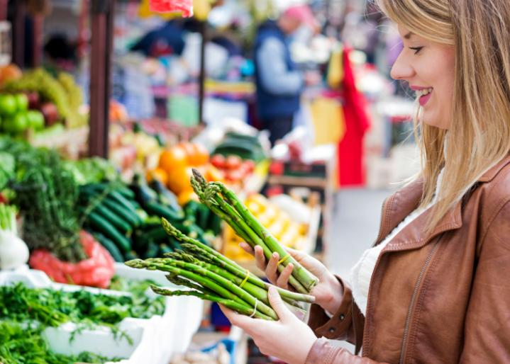 Une femme achète des légumes au marché