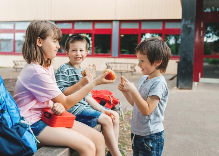 Kinder teilen Snacks im Pausenhof