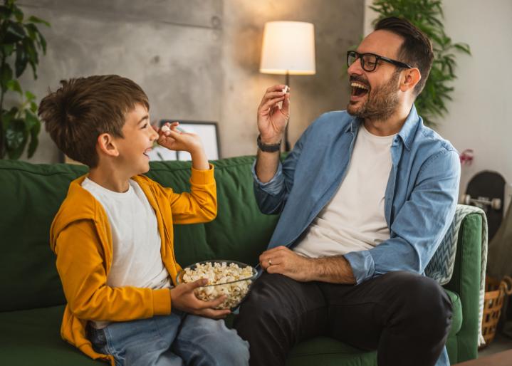 Vater und Sohn essen Popcorn