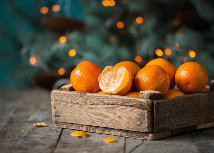 Mandarine und Weihnachtsdekoration mit Tannenbaum und Lichtern