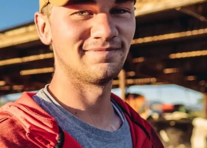 Junger Landwirt vor Viehställen