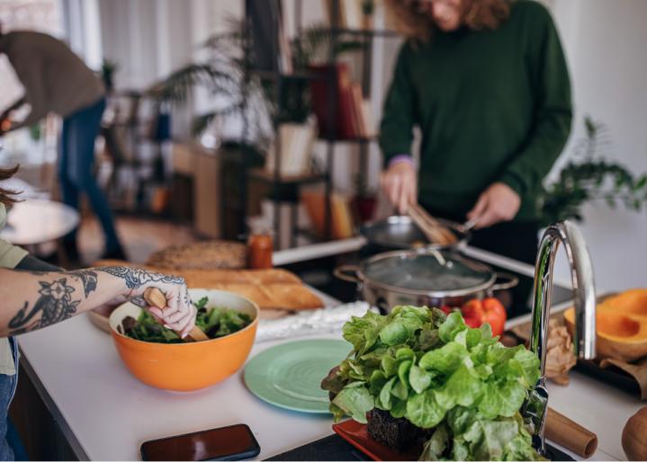 Freunde bereiten gemeinsam das Mittagessen zu