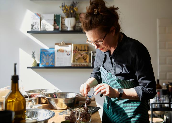 Frau streut gewuerze ueber essen