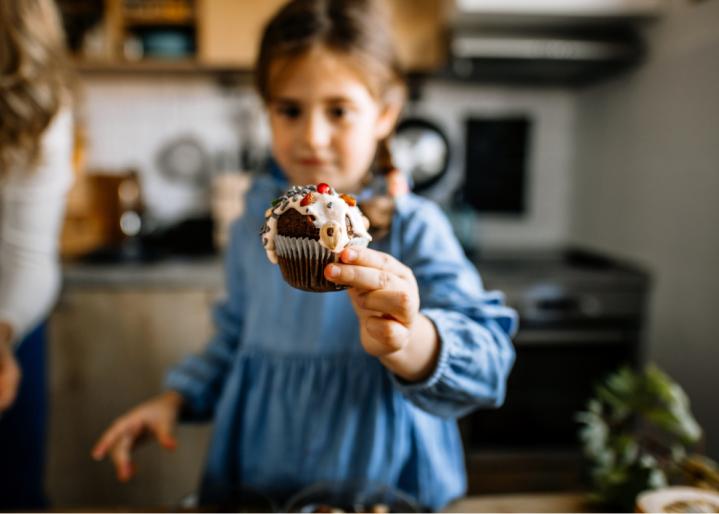 Kind das einen Cupcake in der Hand hält