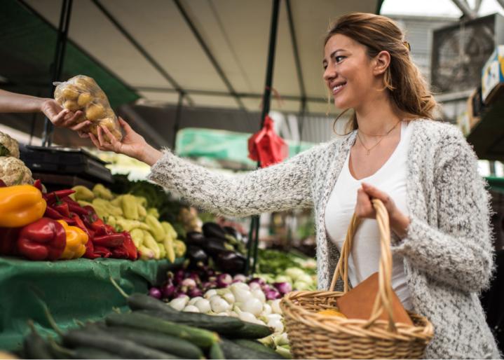 Frau kauft Gemüse ein