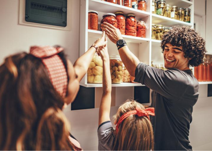 Eine-Familie-räumt-Gläser-in-die-Speisekammer