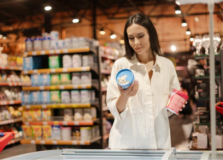 Frau wählt im Supermarkt eine Glace aus