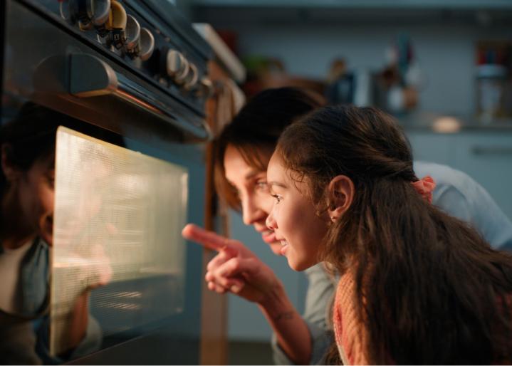 La mère et la fille regardent dans le four